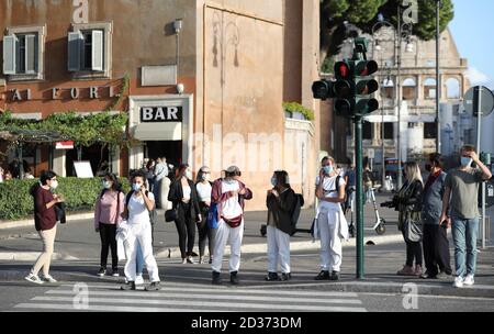Rome, Italy. 6th Oct, 2020. People wearing face masks wait to cross a street in Rome, Italy, Oct. 6, 2020. Five southern regions of Italy have introduced mandatory mask laws, even for people in open spaces. And the government has announced that the national state of emergency, first put into place on Jan. 31, would be extended 'at least' until its one-year anniversary. Credit: Cheng Tingting/Xinhua/Alamy Live News Stock Photo