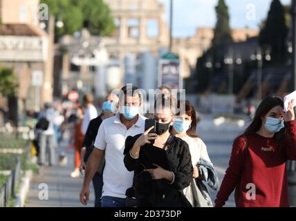 Rome, Italy. 6th Oct, 2020. People wearing face masks walk on Via dei Fori Imperiali in Rome, Italy, Oct. 6, 2020. Five southern regions of Italy have introduced mandatory mask laws, even for people in open spaces. And the government has announced that the national state of emergency, first put into place on Jan. 31, would be extended 'at least' until its one-year anniversary. Credit: Cheng Tingting/Xinhua/Alamy Live News Stock Photo