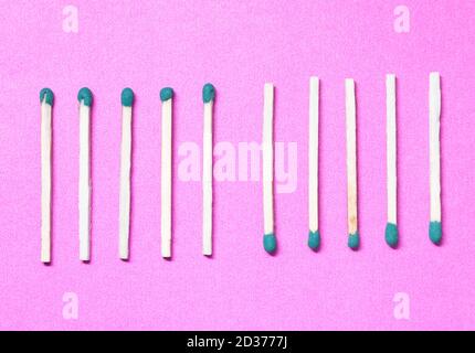Wooden matches not burned aligned with the head in another orientation on a purple background. Stock Photo