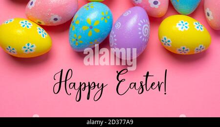 Colorful Easter eggs on pink background with greeting  Stock Photo