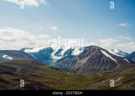 Scenic landscape with great mountain range and glacier. Snow on top of giant mountain ridge. Beautiful big snowy mountains in sunny day. View from pas Stock Photo