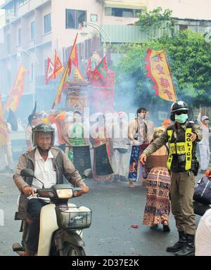 Phuket Town / Thailand - October 7, 2019: Phuket Vegetarian Festival or Nine Emperor Gods Festival procession with man driving motor scooter, a police Stock Photo