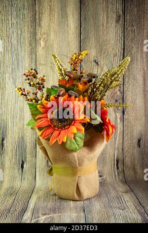 Orange decorative sunflower and two acorns isolated on the wood background. Thnksgining content Stock Photo