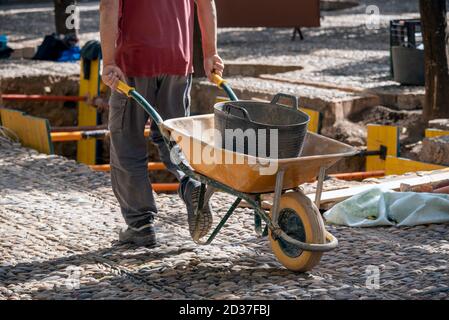 A person drives a car that has a door inside and in the background you can see a construction site container Stock Photo