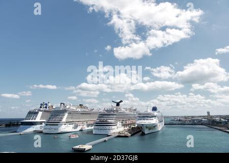 Nassau, Bahamas-February 18, 2016: Large luxury cruise ships of Carnival, Norwegian and Royal Caribbean cruise lines docked in port of Nassau, Bahamas on sea water and cloudy sky background Stock Photo