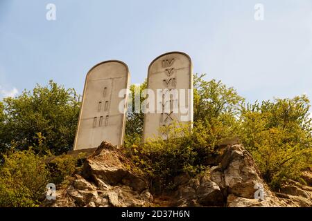 Stone tablets on a rocky hill with carved 10 commandments Stock Photo