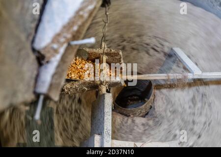Grind corn in an old mill. The millstones are spun and ground corn or wheat flour Stock Photo