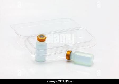 Two vaccine bottle one inside and one outside an opened translucent plastic box for ten vaccine bottles Stock Photo
