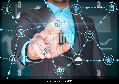 Businessman pressing a virtual screen configuration button. Technical monitoring of a factory. Concept of industry, business. Stock Photo
