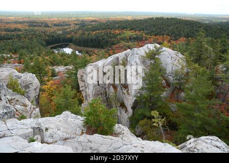 The view of autumn tree colours and quartzite rocks from the top of The Crack hiking trail, Killarney Provincial Park, Ontario, Canada. Stock Photo