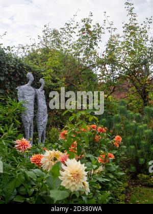 Chenies Manor gardens in September. Victoria Atkinson's sculpure, 'Halcyon' among the Dahlia 'Nicolas', an ivy and Akebia clad trellis.and arches. Stock Photo