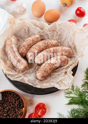 fresh homemade sausage on a light background with vegetables Stock Photo