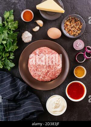 fresh raw minced pork in a wooden bowl with vegetables on the background Stock Photo