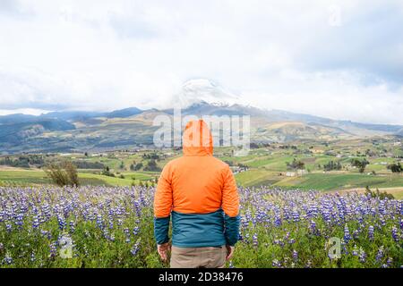 Young man standing in fron of Cotopaxi mountain in los Andes Ecuador Stock Photo