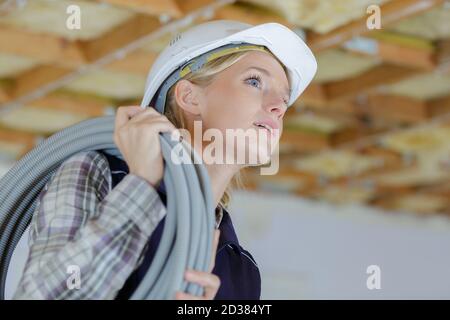 female electrician installing ventilation in ceiling Stock Photo