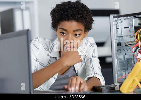 female computer technician looking at laptop Stock Photo