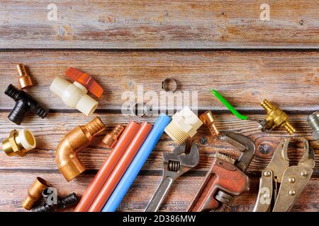 Installation of plastic pipes for the water system, pipe cutting tools, corners, holders, taps, adapters and work gloves on equipment for plumbing at construction site Stock Photo
