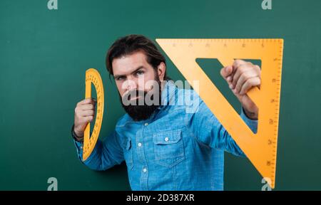formal education. male student at mathematics school lesson. pass the math exam. learning the subject. serious man with beard using triangle ruler. studying the measurement. Stock Photo