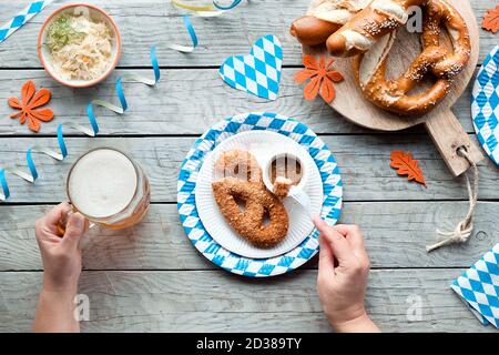 Celebrating Oktoberfest alone. Traditional food and beer, top view on aged wood. Stock Photo