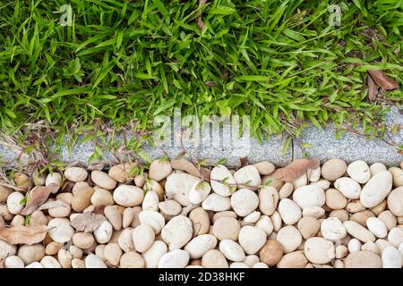The junction of the lawn and the cobblestone road in the park Stock Photo