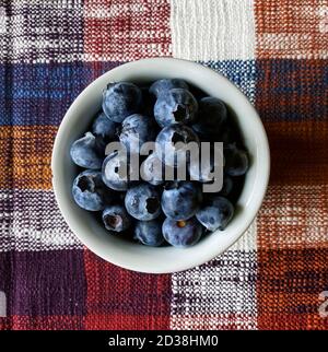 fresh blueberries in a bowl over a fall tablecloth Stock Photo