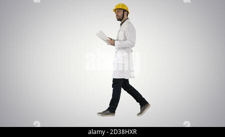 Engineer manager walking with hard hat is holding paper and chec Stock Photo