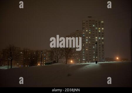 City at night in Russia during winter, high storey buildings in winter fog with their lights diffused Stock Photo