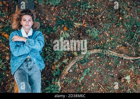 A girl in the woods on a tree, a view from above. Stock Photo