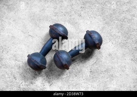 Old iron dumbbells on cement floor. Top view Stock Photo