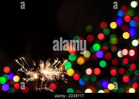 Sparklers with sparks and bokeh on black background with place for text. Stock Photo