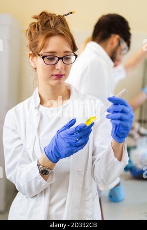 Young attractive female scientist researching in the laboratory Stock Photo