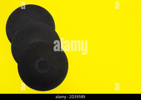 A cut-off wheel for a grinder tool on a yellow background with a place for copyspace text. Tools for construction and repair, workshop Stock Photo