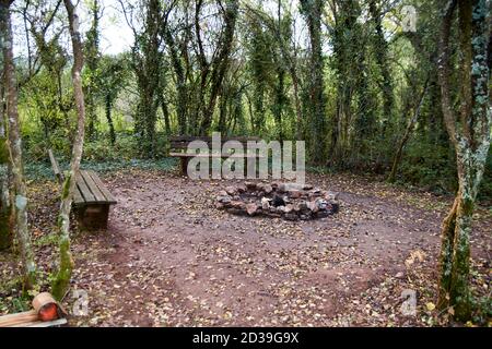 Stone fireplace photographed with a wooden bench in nature. Stock Photo