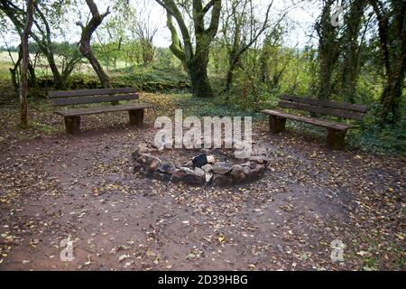 Stone fireplace photographed with a wooden bench in nature. Stock Photo