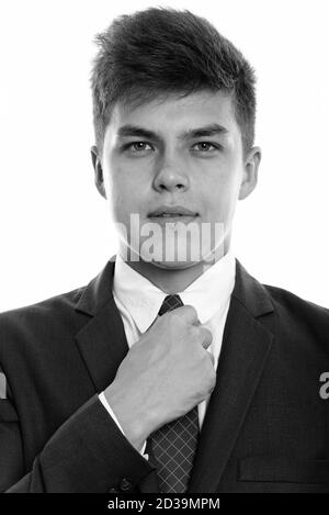 Face of young handsome businessman fixing tie Stock Photo