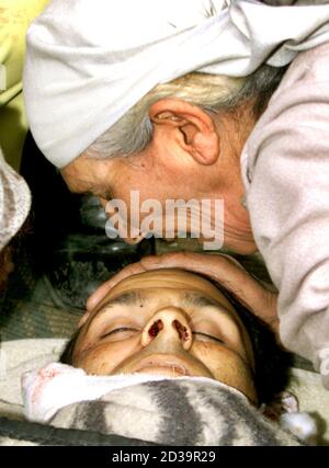 Kashmiri Muslim woman kisses the body of Mukhtar Ahmad, a pro-India politician, in Srinagar March 18, 2004. Suspected Muslim rebels on Thursday shot dead Ahmad, a senior member of Janata Dal, a pro-India political party, outside his home in Srinagar, the summer capital of troubled Jammu and Kashmir, police said. REUTERS/Danish Ismail