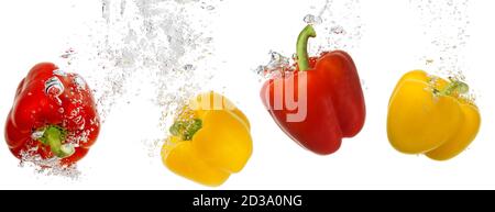 four bell peppers falling into water isolated on white background Stock Photo