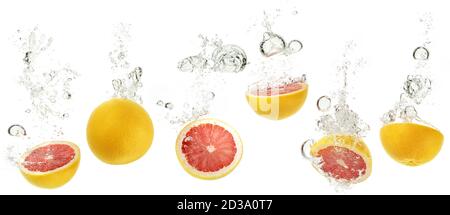 set of grapefruits dropping into water on white background Stock Photo