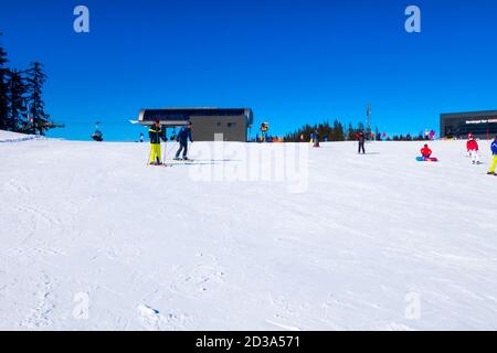 Saalbach, Austria - March 2, 2020: People skiing at ski slope of austrain winter resort Stock Photo