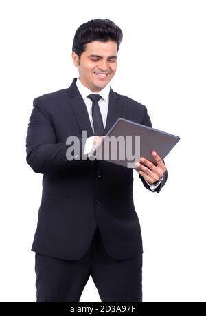 Smiling young businessman using digital tablet on white background Stock Photo