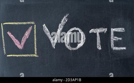 Vote Written On Blackboard. The concept of making choices. Presidential and parliamentary elections. Calling for voting, democracy. Stock Photo