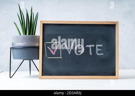 Vote Written On Blackboard. The concept of making choices. Presidential and parliamentary elections. Calling for voting, democracy. Stock Photo