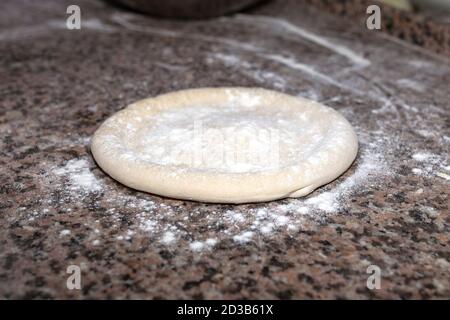 Rolled out pizza dough on floured slate surface. Horizontal image Stock Photo