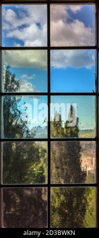 A window with multi-colored glass that overlooks a park Stock Photo