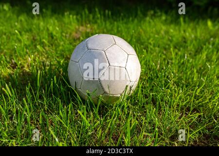 Football, sports. A fine green meadow with a soccer ball on it Stock Photo