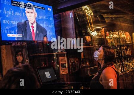 Athens, United States. 07th Oct, 2020. A bartender wearing a facemask is seen captivated by Mike Pence's answers to questions during the Vice Presidential Debate. Patrons of Tony's, a local bar in Athens, Ohio have a drink as they watch Vice President, Mike Pence and Democratic Vice Presidential nominee Kamala Harris, square off in a debate in Salt Lake City, Utah hosted by Vice News. Credit: SOPA Images Limited/Alamy Live News Stock Photo