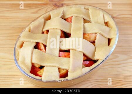 Bowl of raw apple pie with decorative woven lattice top crust ready for baking Stock Photo