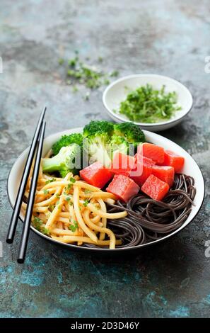 Bamboo shoots, fern root noodles, broccoli, micro greens and sockeye salmon bowl, selective focus Stock Photo