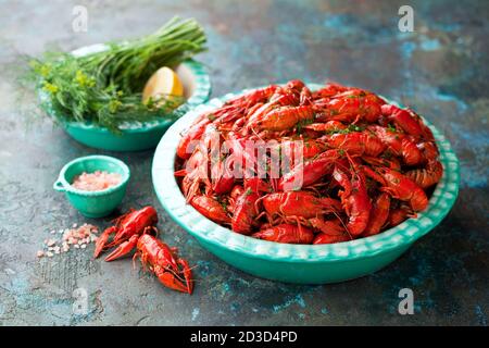 Boiled red crayfish with dill in a bowl on the table, selective focus Stock Photo