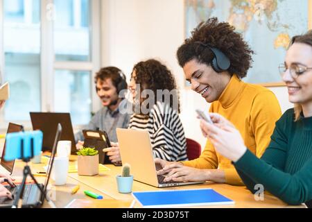 Young friends working together inside co-working creative space - Teamwork doing startup strategy in modern office Stock Photo